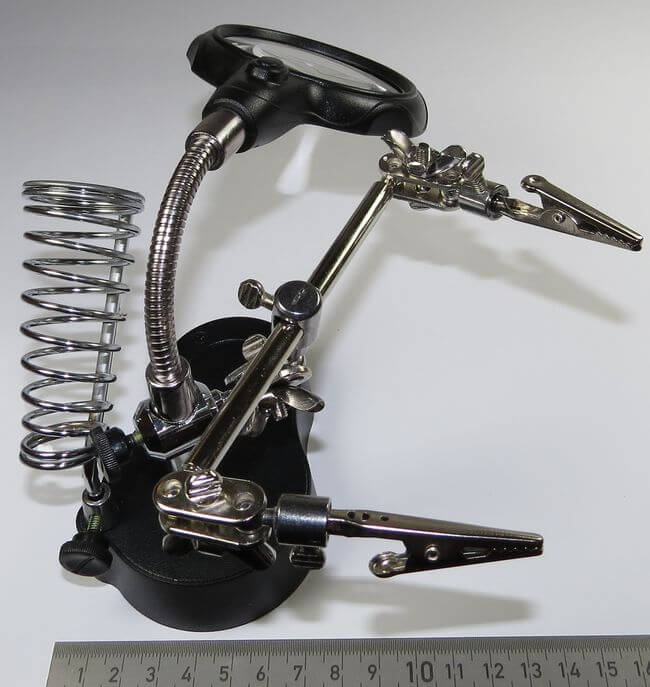 Helfende Hand mit Lupe. Stabiler Stand-  Fuss aus