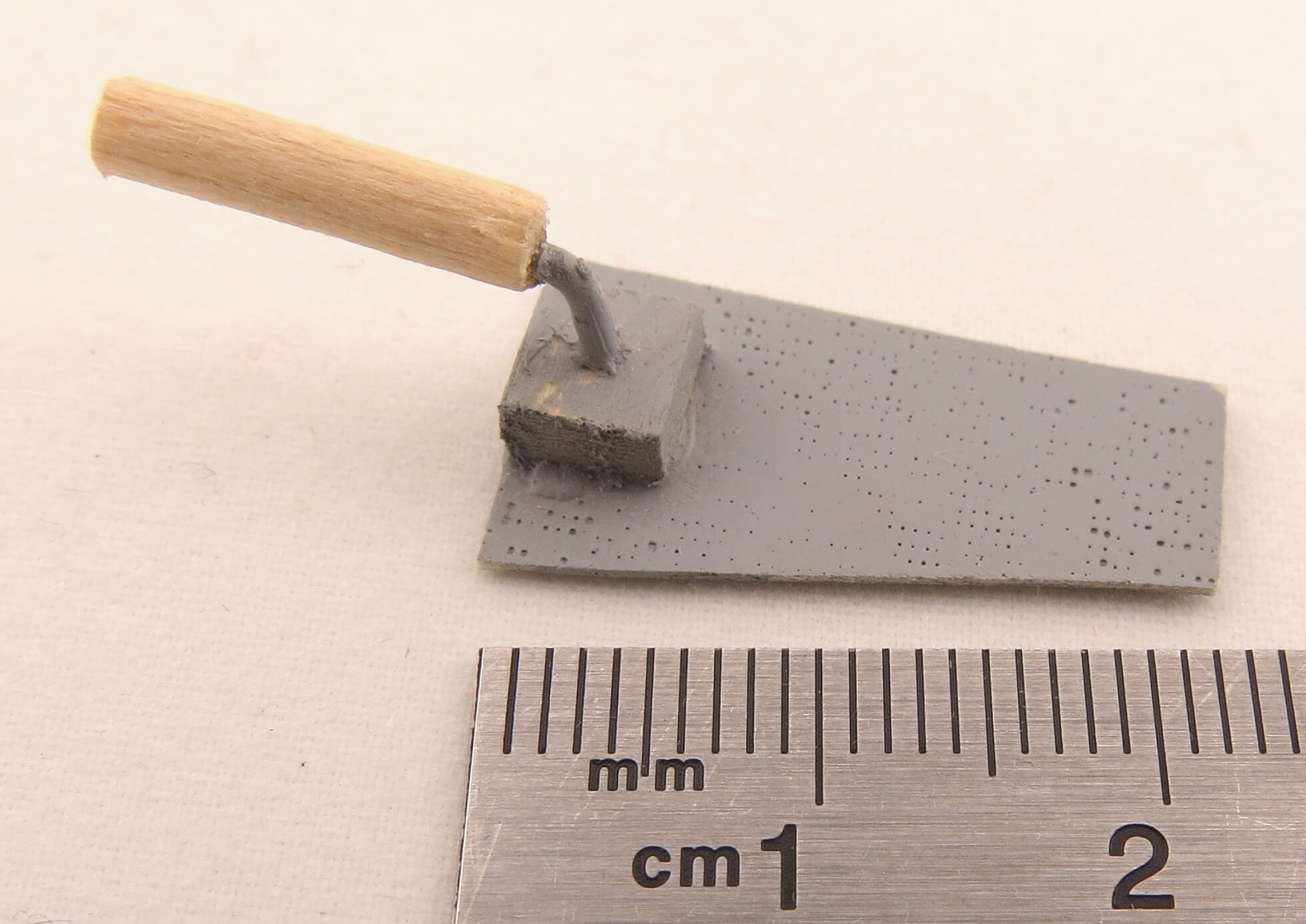 1 Maurerkelle ca. 3cm lang. Vorne stumpf, mit Holzgriff.